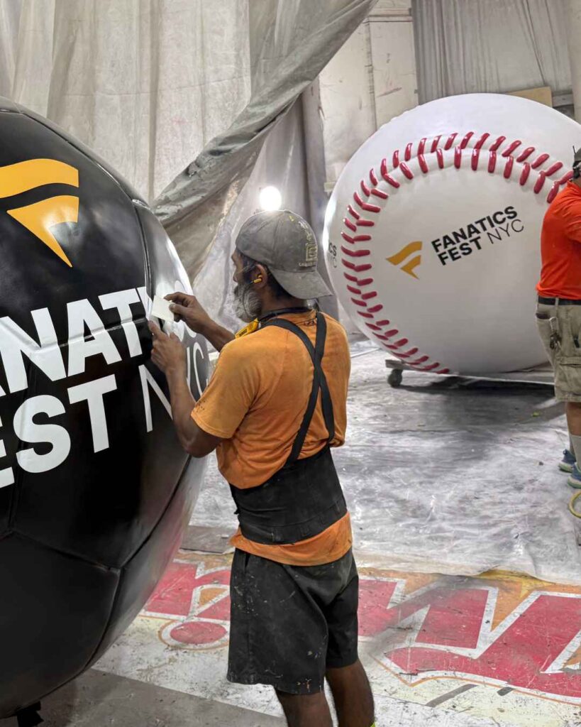 A Smash Design artist paints one of the huge foam sculptures for Fanatics Fest 2026